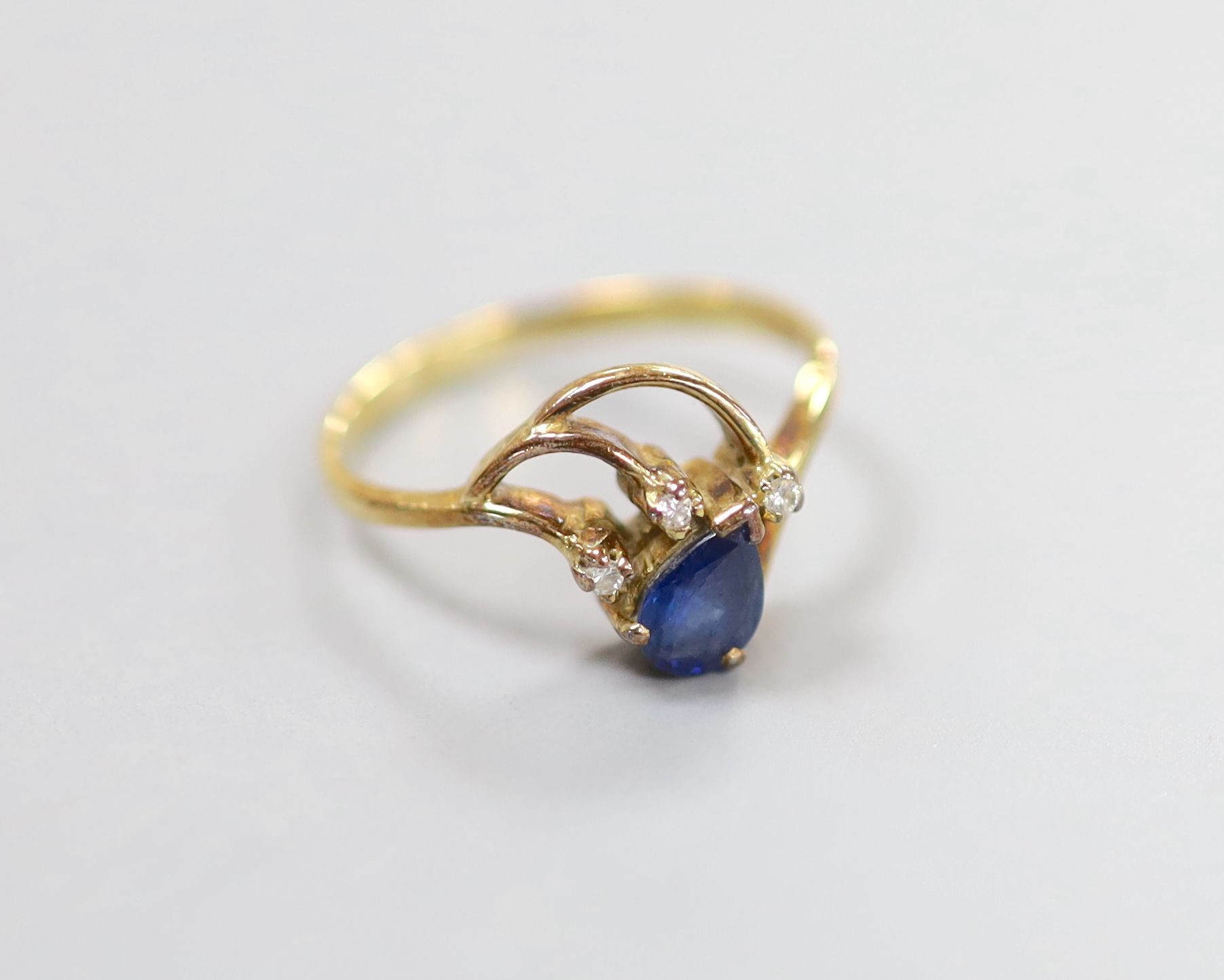 A yellow metal, pear cut sapphire and three stone diamond chip set ring, size J, gross 1.8 grams.